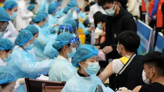 Medical workers give students the vaccine at a university in Qingdao, Shandong province, China