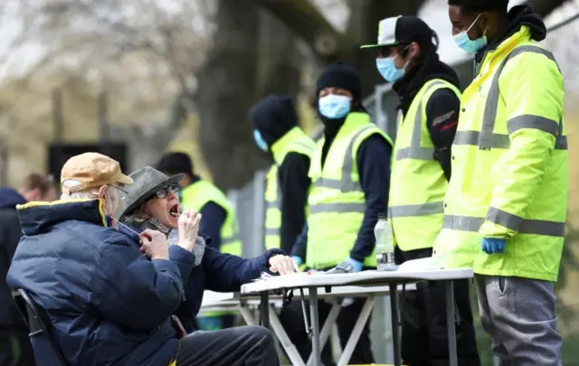 People swab themselves for coronavirus disease (COVID-19) at a testing site on Clapham Common in London