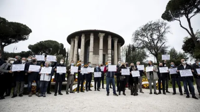 Undertakers from Rome protest with placards reading: "Excuse us, but they do not allow us to bury your loved ones"