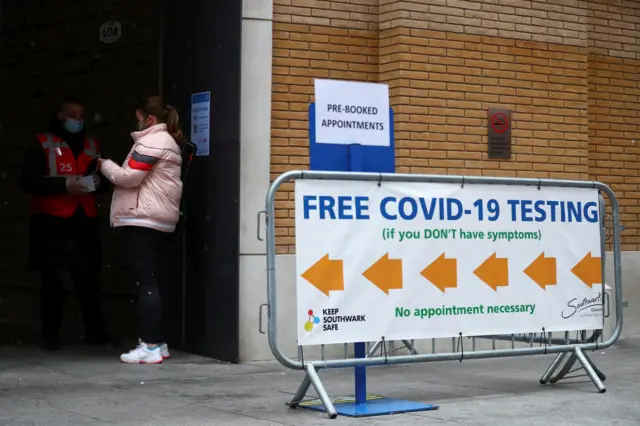 People stand outside a coronavirus test centre at London Bridge Station