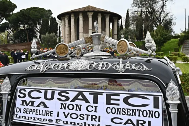 A hearse with a placard that reads: "Sorry, but they don't let us bury your loved ones" is parked close to funeral home workers protesting at the ancient Roman "Hercules the Winner"