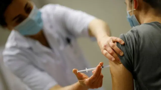 A healthcare worker administers a dose of the Pfizer-BioNTech Covid-19 vaccine