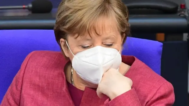 German Chancellor Angela Merkel wears a face mask as she looks on during a session of the German parliament Bundestag in Berlin, Germany, 16 April 2021