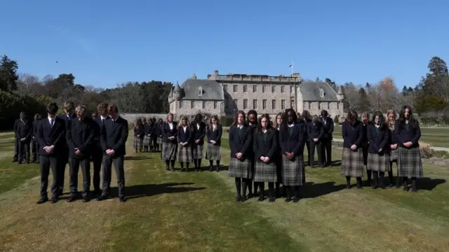 Pupils of Gordonstoun School stand during a minute's silence