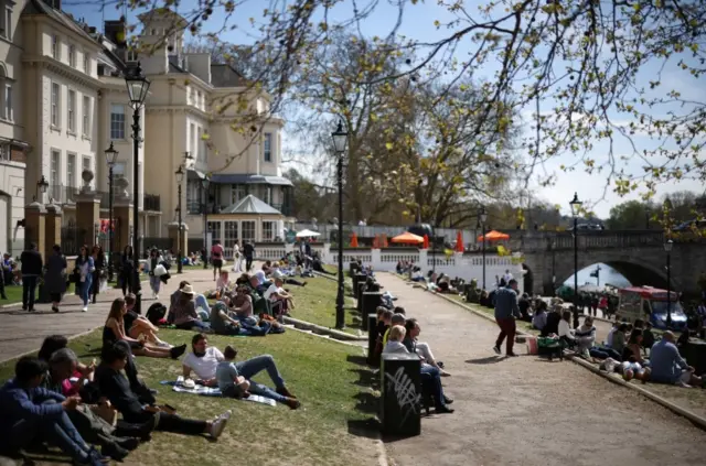 People relax on bank of the River Thames in Richmond