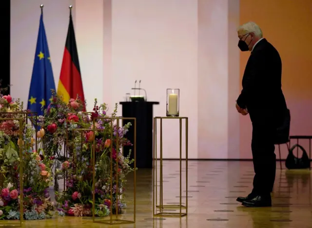 German President Frank-Walter Steinmeier stands in front of a candle during a ceremony for Germany's victims of the coronavirus