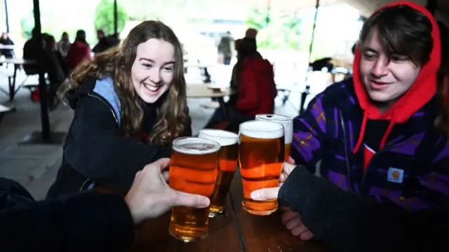 People enjoying beers in an outdoor pub setting