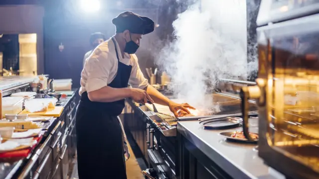 Chef cooking wearing face mask.