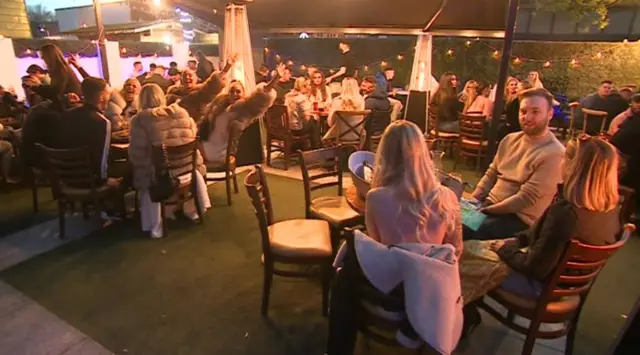 Customers in a beer garden sitting at tables