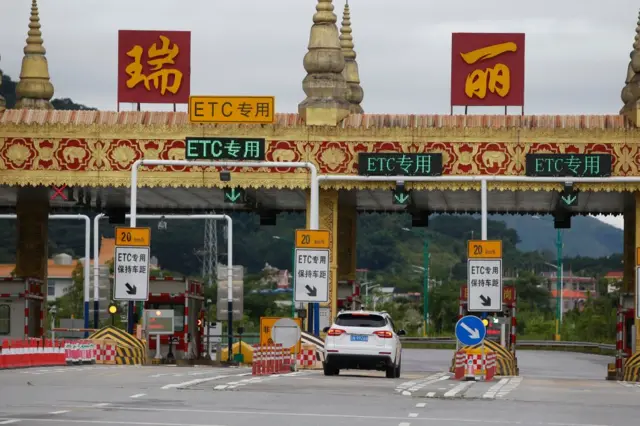 A car is driven through a toll station of an express way in Ruili, China