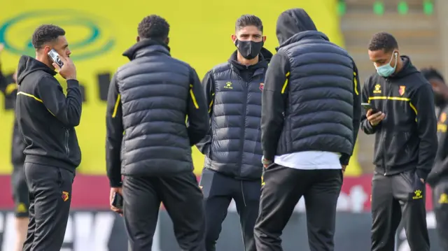 Watford players assess the pitch