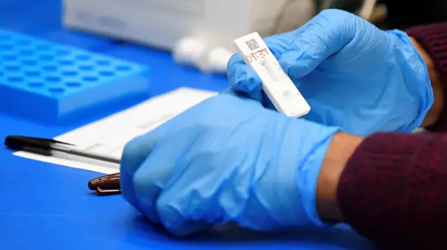 Health workers handling lateral flow test samples