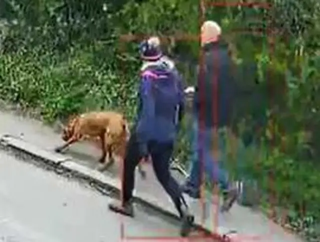 CCTV image of two people and dog