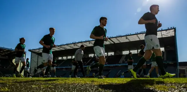 Hibs players warm up in the Edinburgh sunshine