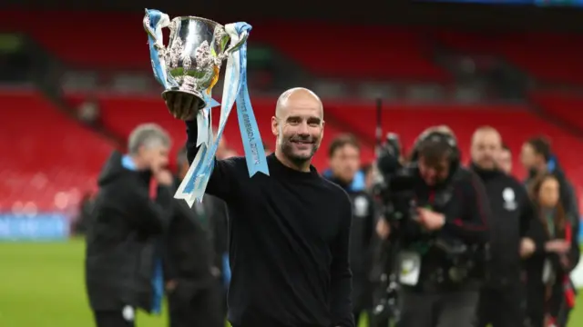 Pep Guardiola lifts the League Cup