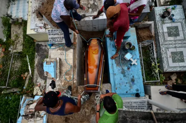 Gravediggers bury a COVID-19 victim at the municipal cemetery in Brazil