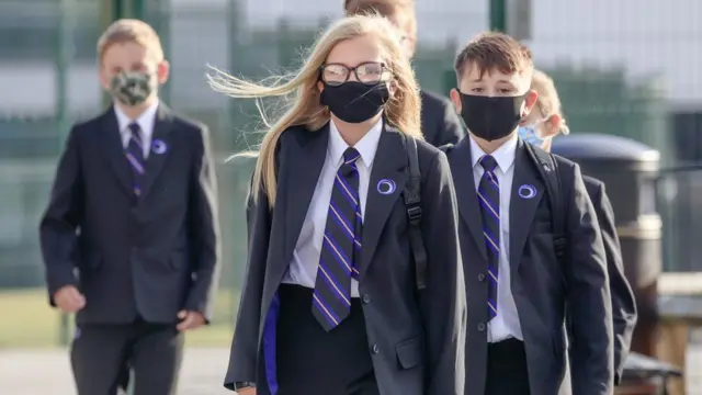 Children in school uniforms and masks