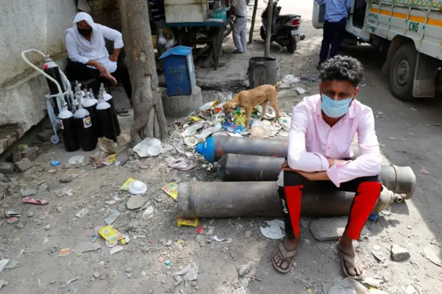 Sumit Kumar, 28, sits on an oxygen cylinder