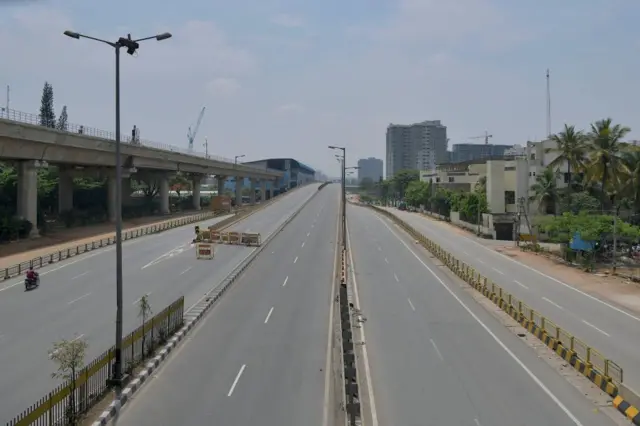 A partially deserted road is pictured during the weekend lockdown imposed as a preventive measure against the spread of the Covid-19 coronavirus in Bangalore on April 24, 2021. (