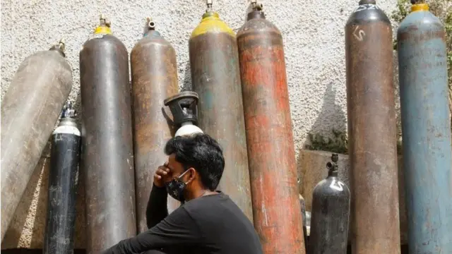 File photo of man in front of oxygen cylinders