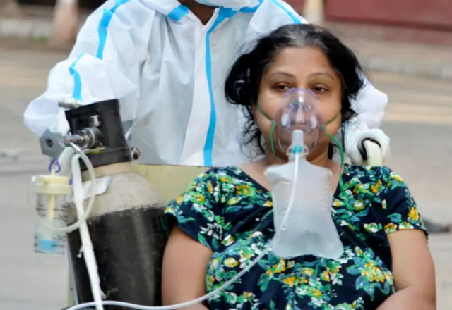 A Covid-19 patient on a wheel chair goes for a medical test inside a government hospital in Kolkata