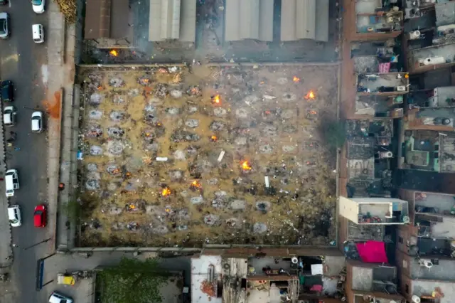 In this aerial picture taken on April 26, 2021, burning pyres of victims who lost their lives due to the Covid-19 coronavirus are seen at a cremation ground in New Delhi.