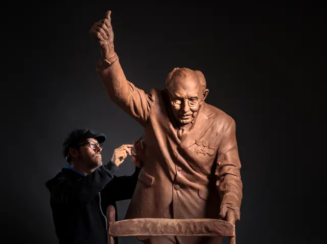 Andrian Melka puts the finishing touches to his two-metre high clay statue of Captain Sir Tom Moore