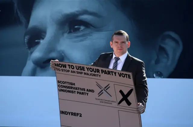 Douglas Ross with a giant mock-up peach ballot card