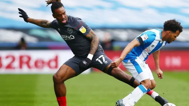 Brentford's Ivan Ivan Toney tussles with Huddersfield's Duane Holmes