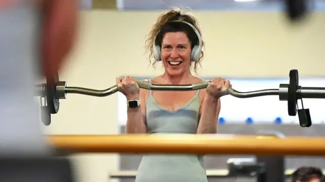 A woman lifting weights in a gym