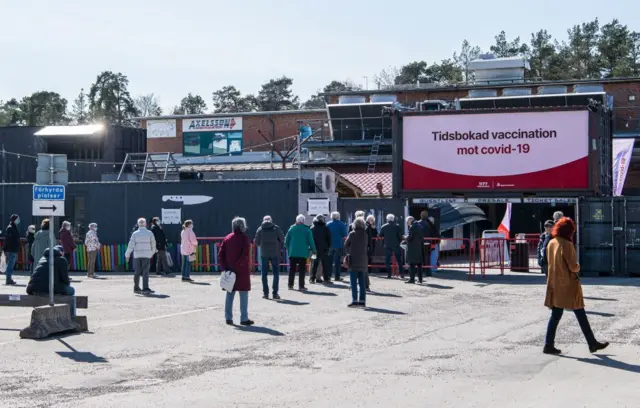 People queue to get their vaccines outside a nightclub turned mass vaccination centre in Stockholm, Sweden