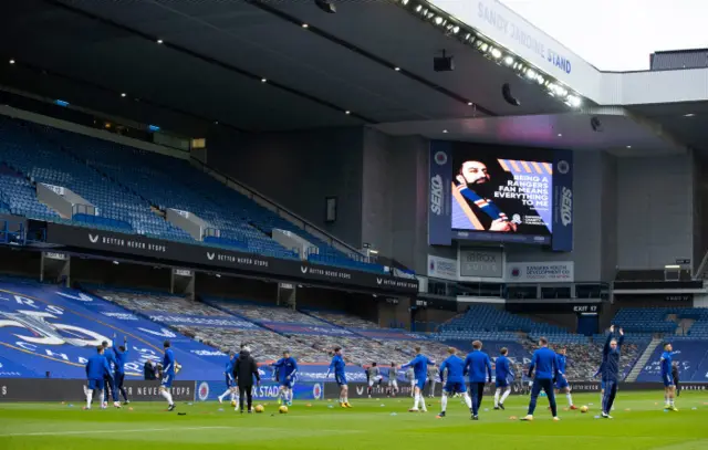 The players warm up at Ibrox