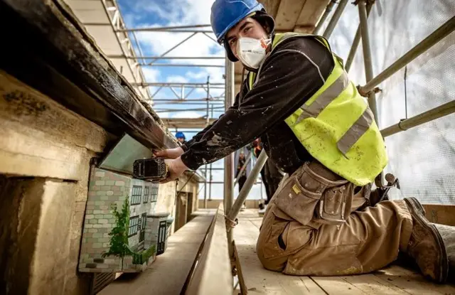 Construction worker installs bat box