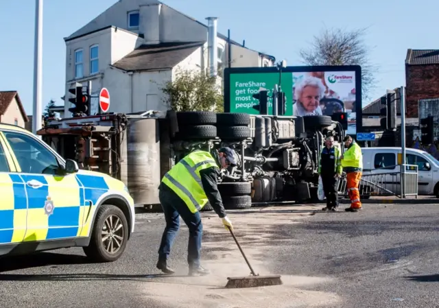 Bin lorry overturns