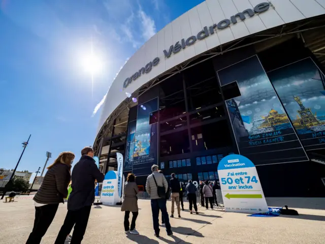 People line up to get vaccinated in front of the Velodrome stadium on 15 March 2021 in Marseille, southern France