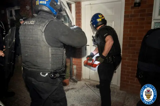 Police officers raiding a house