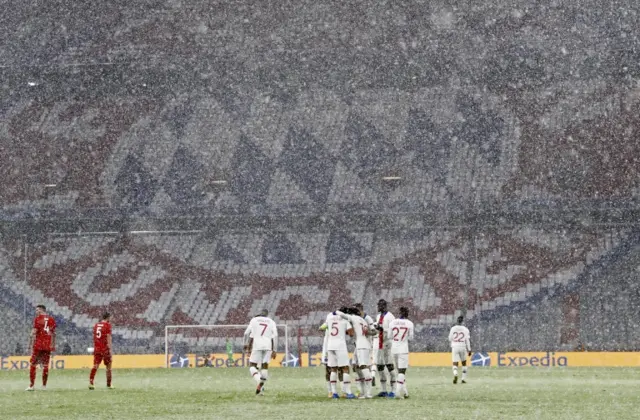 Paris St-Germain players celebrate a goal in heavy snow away to Bayern Munich