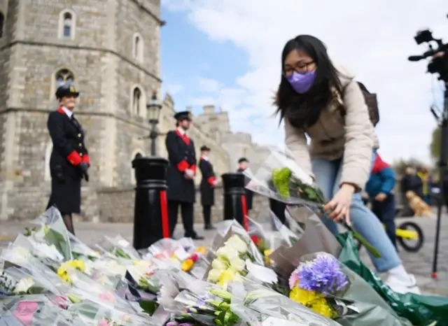 People placing flowers with condolence messages outside Windsor Castle