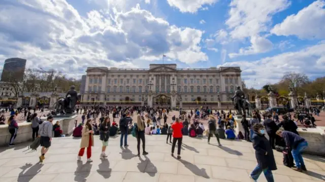 People gather outside Buckingham Palace in the sunshine