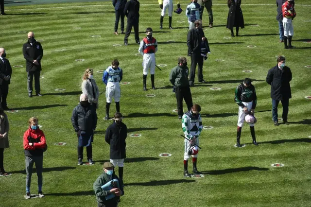 Racegoers and riders observe a two-minute silence for the late Prince Philip whilst social distancing