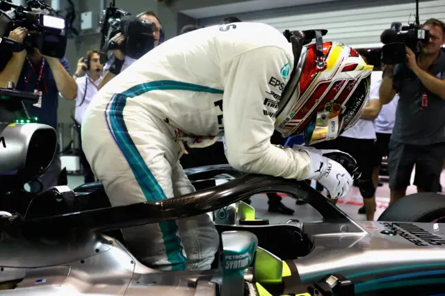 Lewis Hamilton slumps over his car after securing pole in Singapore 2018