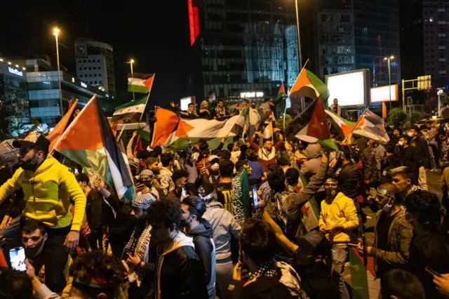 Protestors wave Palestinian flags during a demonstration in front of the Israel Consulate in Istanbul (12 May 2021)