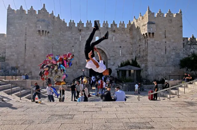 A young Palestinian man performs outside the Damascus Gate in Jerusalem's Old City during Eid al-Fitr