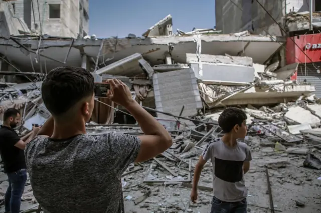 Palestinians inspect a destroyed house after an Israeli airstrike on the Gaza Strip