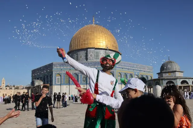 Muslim children celebrate in front of the Dome of the Rock mosque after the morning prayer at the Al-Aqsa mosques compound in Old Jerusalem