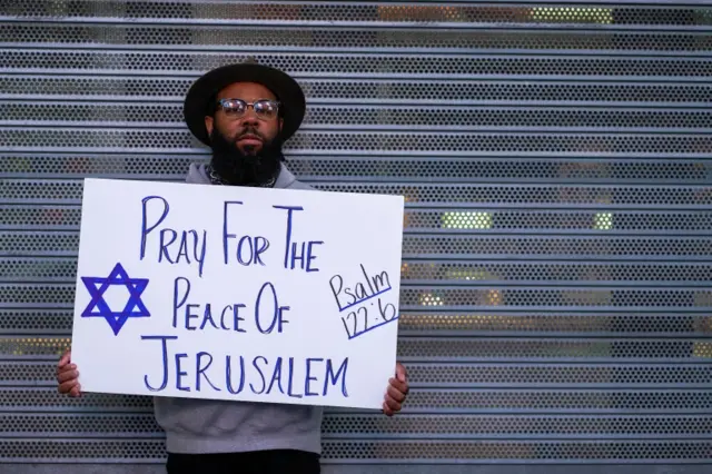 A person holds a sign that reads "Pray for the Peace of Jerusalem" at a pro-Israel rally at Times Square in New York City  (12 May 2021)