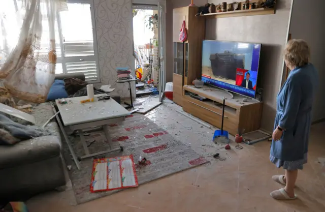 An Israeli woman checks the damage inside her house in Ashkelon