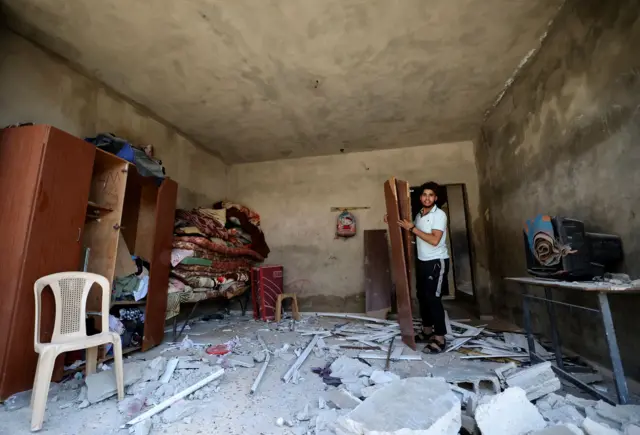 A Palestinian man inside a home hit by an Israeli air strike, in Beit Hanun in the northern Gaza Strip.