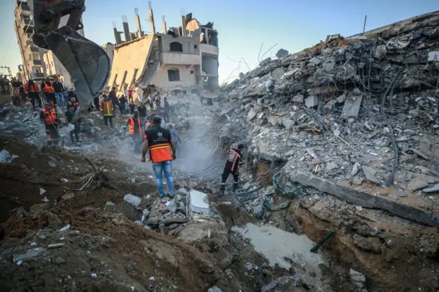 Palestinian civil defense teams take part in rescue works at the rubbles of a building belonging to a Palestinian family after Israeli fighter jets conducted airstrikes in Beit Lahia, Gaza