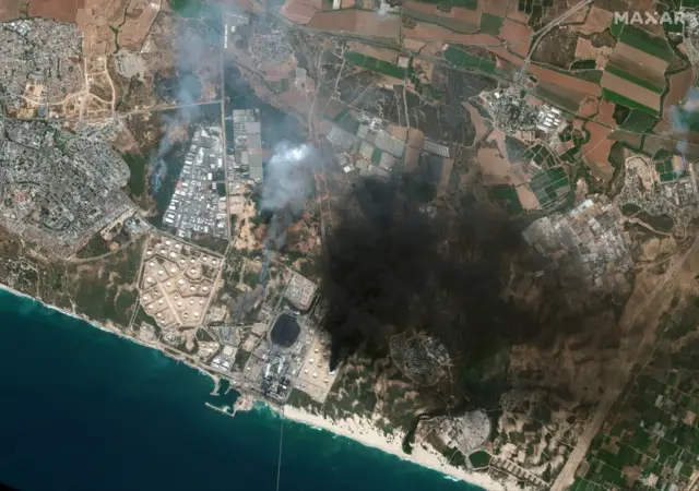 A handout satellite image made available by MAXAR Technologies shows an overview of Ashkelon and a burning storage tank in southern Israel, on 12 May 2021 (issued 13 May 2021)